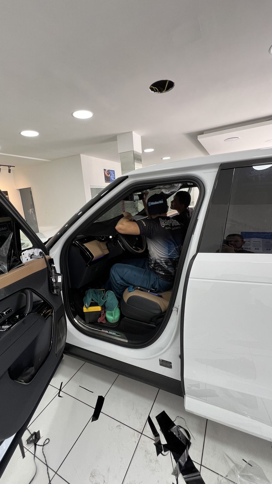 Técnico da Center Films aplicando película Window Blue no vidro lateral de um Range Rover